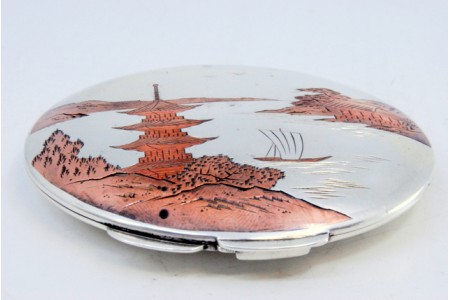 Caixa de toilette em prata com motivos asiáticos gravados na tampa e espelho no interior.